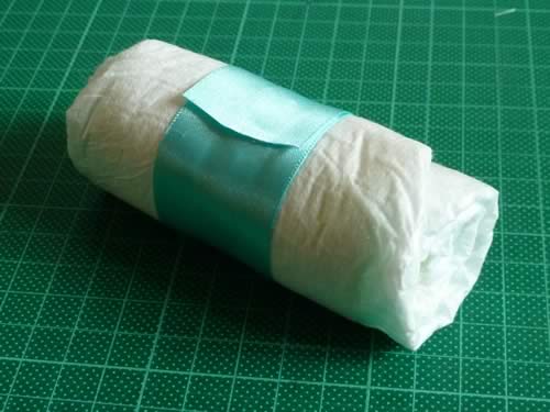 rolled diaper wreath step 2 wrap diaper in ribbon