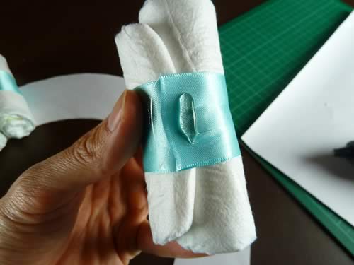 rolled diaper wreath step 3 glue diapers to wreath