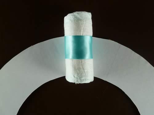 rolled diaper wreath step 3 glue diapers to wreath