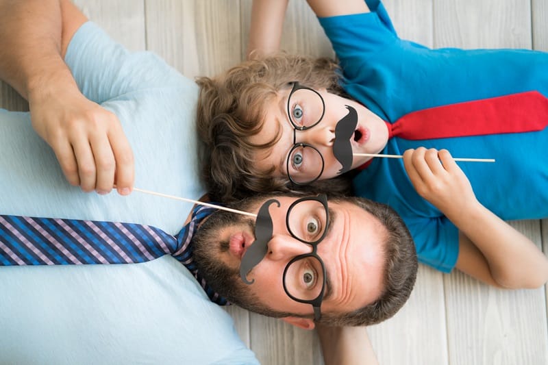 happy fathers day dad and son playing around with fake mustaches