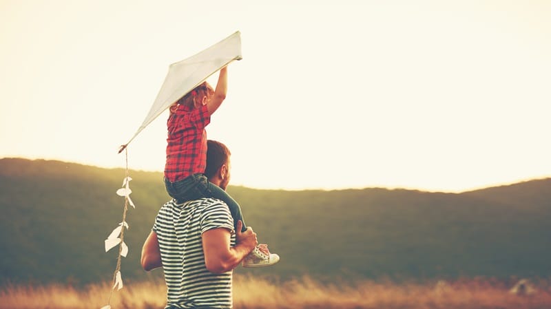 happy fathers day dad and kid flying a kite