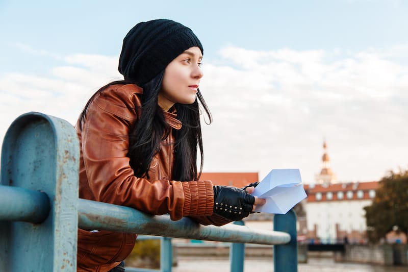 love letters for her young woman gazing into distance holding letter